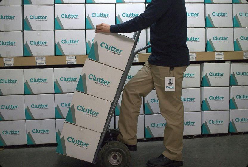 Clutter team member moving Clutter by Iron Mountain boxes with a hand truck