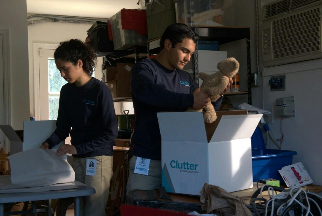 Clutter team packing items into branded boxes